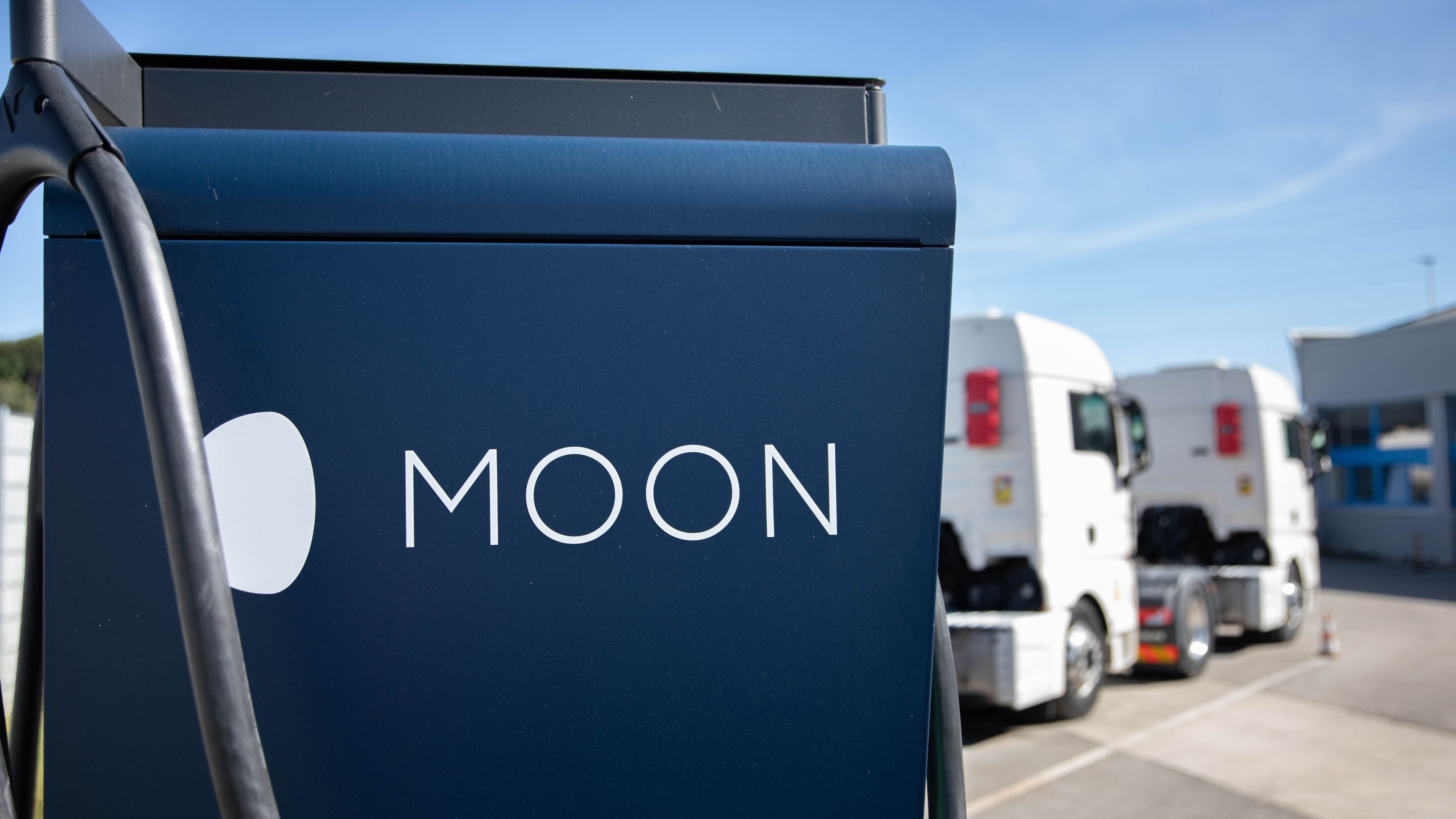 two trucks are parked behind a HYC 200-400 fast charging station