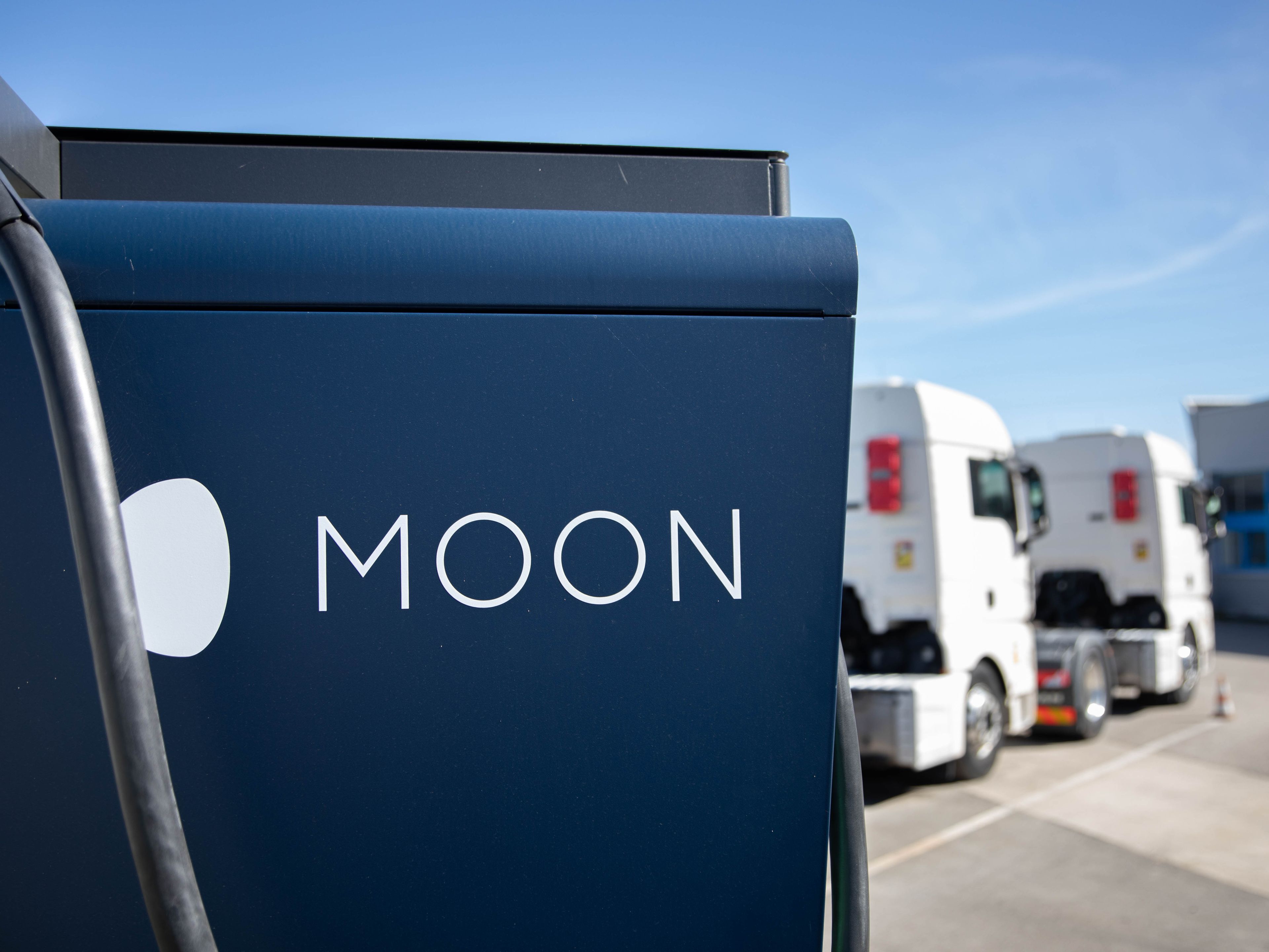 two trucks are parked behind a HYC 200-400 fast charging station