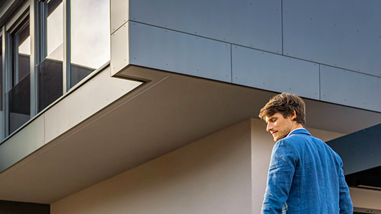 Person walks towards an electric car with cable in hand