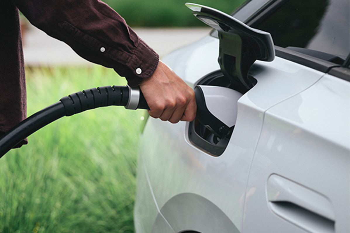 Person holding tap valve into an electric car