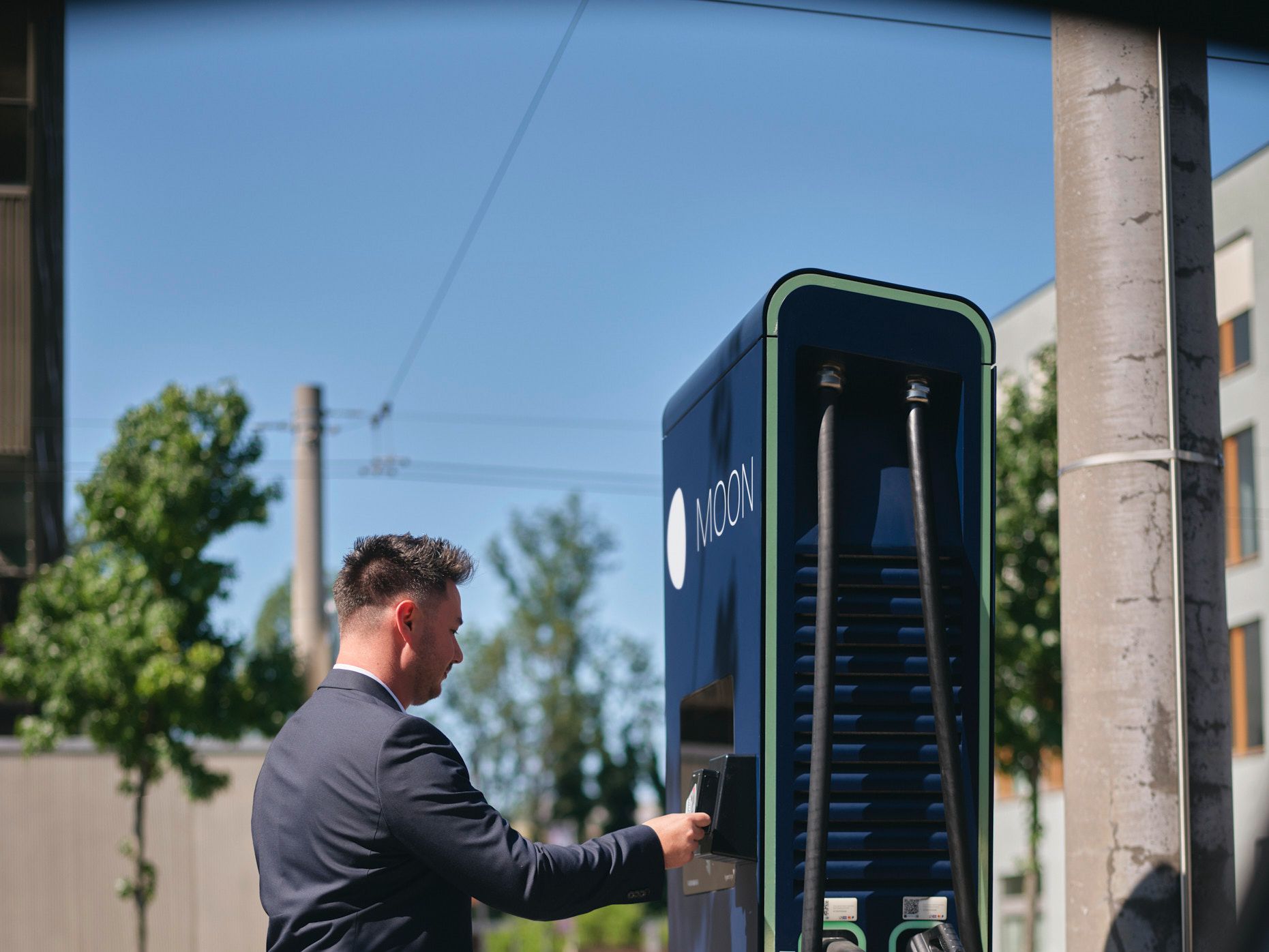 Man holds card to a fast charging station